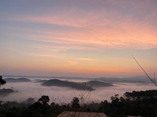 a view of a foggy valley with mountains in the background at Mây và Mây - Homestay Măng Đen in Kon Von Kla