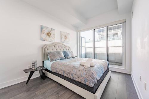 - une chambre avec un lit et une grande fenêtre dans l'établissement 660sqf Condo by Lake close to Airport, Parking!, à Toronto