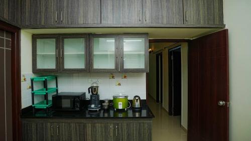 una cocina con encimera y cafetera. en Deltin Royal Stays 3 Bedroom Apartment, en Hyderabad