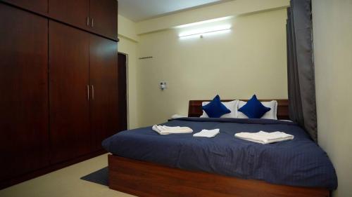 1 dormitorio con 1 cama con sábanas azules y almohadas azules en Deltin Royal Stays 3 Bedroom Apartment, en Hyderabad