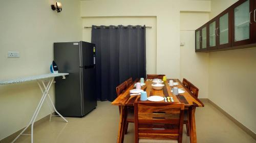 cocina con mesa de madera y nevera en Deltin Royal Stays 3 Bedroom Apartment, en Hyderabad