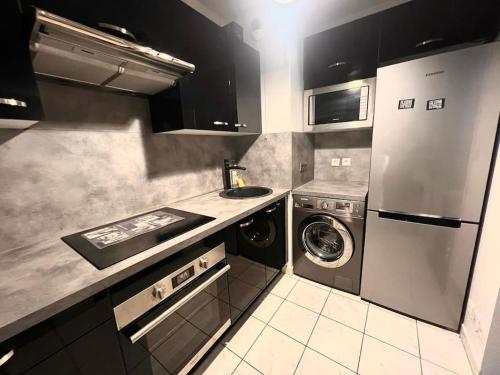 een keuken met een wastafel en een wasmachine bij Créteil - Pointe du Lac - Le So’ in Créteil