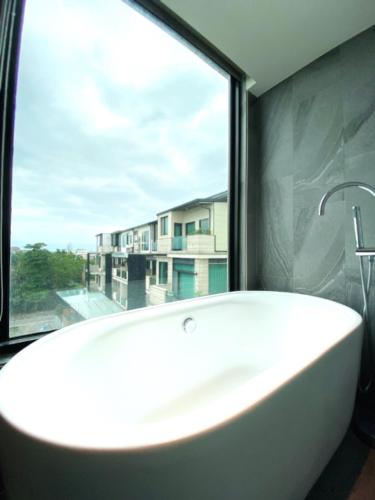 a white bath tub in a bathroom with a window at Tsang Kuo Resort in Wujie