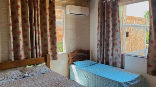 1 dormitorio con 2 camas y ventana en Condomínio Parque de jacuipe, en Camaçari
