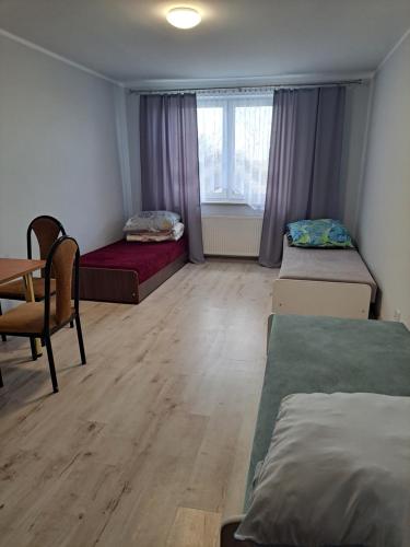 a room with two beds and a desk and a table at Zajazd Izabell 