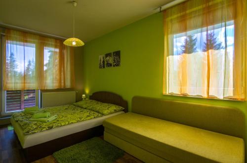 a bedroom with two beds and two windows at Apartman 25 Vysoké Tatry in Štrba