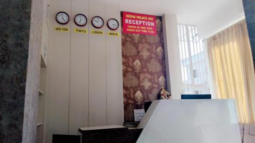 a room with clocks on the wall and a sign at Seema Palace Inn 1 km from Railwaystaion in Mysore