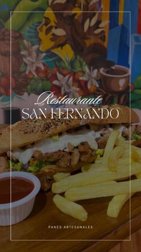 a sandwich and french fries on a cutting board at Hotel y Restaurante San Fernando. in Jocotenango