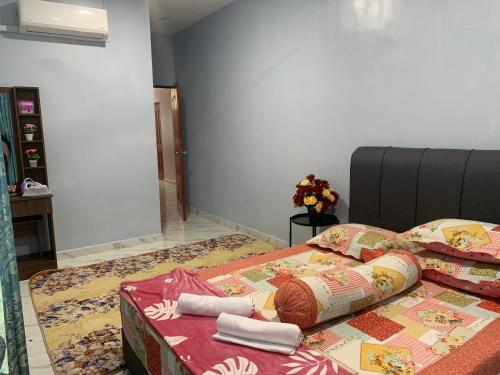 Kampong Sungai LayarにあるTeratak Kasih Homestayのベッド(毛布、タオル付)