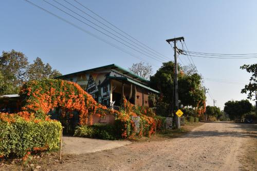a house with flowers on the side of a road at Lodge in the Forest by Giardini Di San Sai in Ban Mai