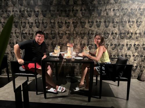 um homem e uma mulher sentados à mesa em Saffron Robes Living em Hikkaduwa