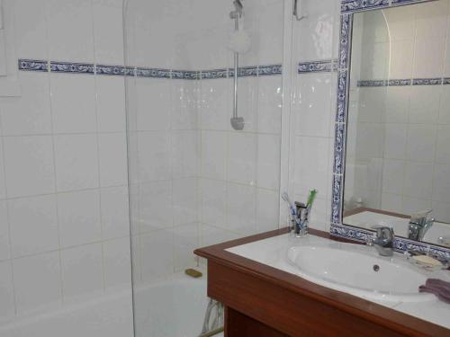 ein Bad mit einem Waschbecken und einer Dusche mit einem Spiegel in der Unterkunft Maison Saint-Jean-de-Monts, 2 pièces, 5 personnes - FR-1-323-509 in Saint-Jean-de-Monts