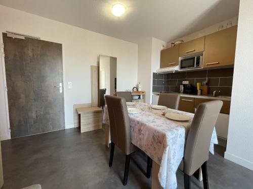 une salle à manger avec une table et des chaises et une cuisine dans l'établissement Appartement 2P à Sète avec Piscine, Clim, Parking et Proche Plages - FR-1-338-556, à Sète