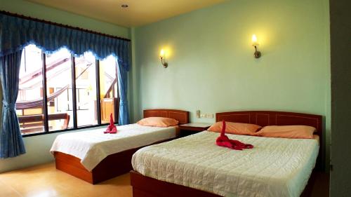 a bedroom with two beds with red bows on them at Black & White Bungalows in Haad Rin