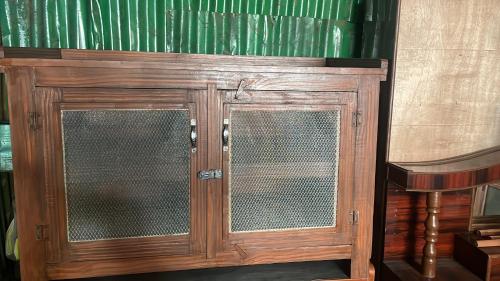 a wooden cabinet with two glass doors in a room at Khadka niwas in Kohalpur