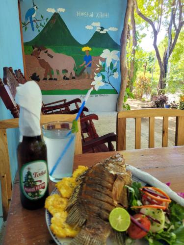 a table with a plate of food and a bottle of sauce at Hostal Xilotl in San José del Sur