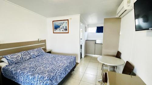 Habitación pequeña con cama y mesa pequeña en Motel Myall, en Dalby