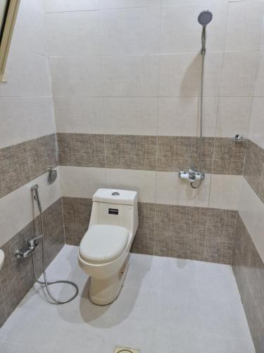 uma casa de banho com um WC e um chuveiro em بيت الجود للأجنحة المفروشة em Sīdī Ḩamzah