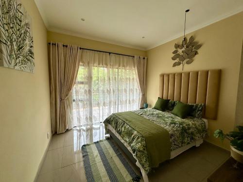 a bedroom with a bed and a large window at Six64 on KINGSWAY B5 in Amanzimtoti