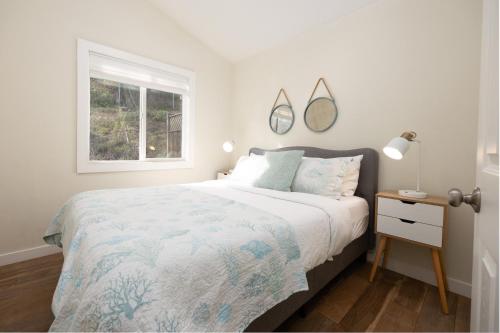 a white bedroom with a large bed and a window at Bright Pacifica Townhouse in Pacifica