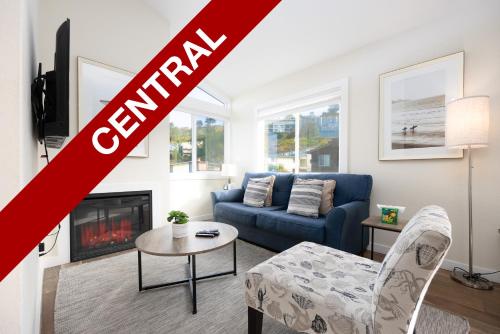 a living room with a blue couch and a fireplace at Bright Pacifica Townhouse in Pacifica
