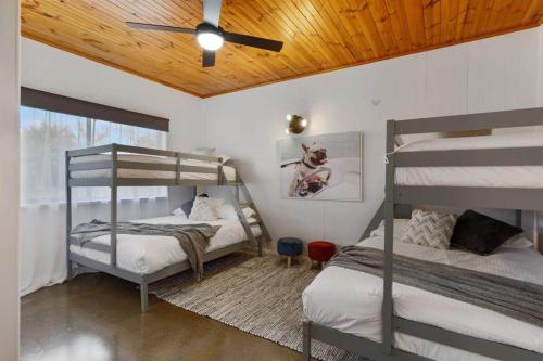 a bedroom with two bunk beds and a ceiling fan at NEW - Hilderton on Hogans in Yarrawonga