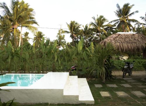uma piscina com uma rampa ao lado de um resort em Single Fin Siargao em General Luna