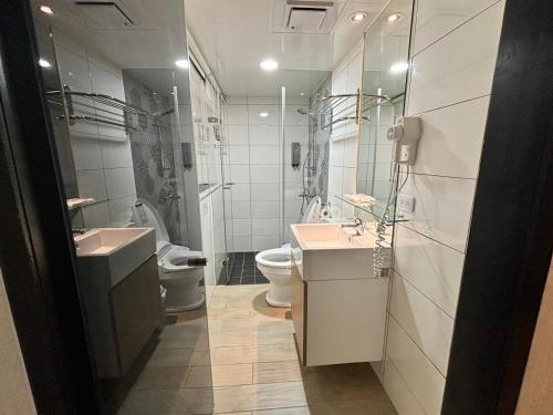 a bathroom with two sinks and a toilet at Formosa 101 Taipei Main Branch in Taipei