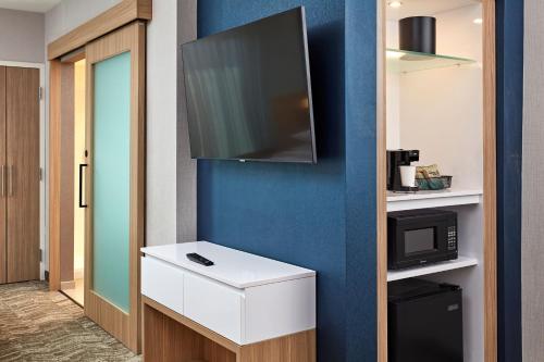 a room with a tv on a blue wall at SpringHill Suites by Marriott Los Angeles Downey in Downey