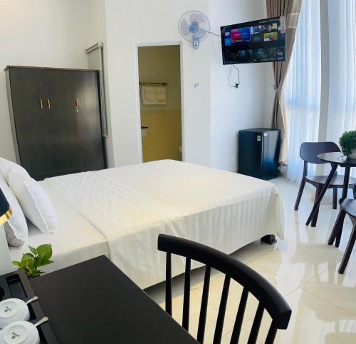 クアンガイにあるKHÁCH SẠN ROMOのベッド、テーブル、椅子が備わるホテルルームです。