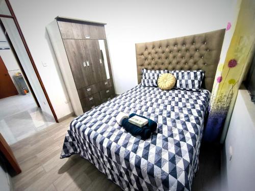 um quarto com uma cama com um cobertor xadrez azul e branco em "Pacae" House em Ica