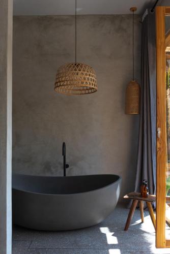 a bath tub in a bathroom with two pendant lights at Be Zanzibar Boutique Hotel in Mfumbwi