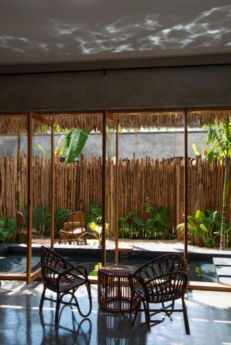 a room with two chairs and a patio with a garden at Be Zanzibar Boutique Hotel in Mfumbwi