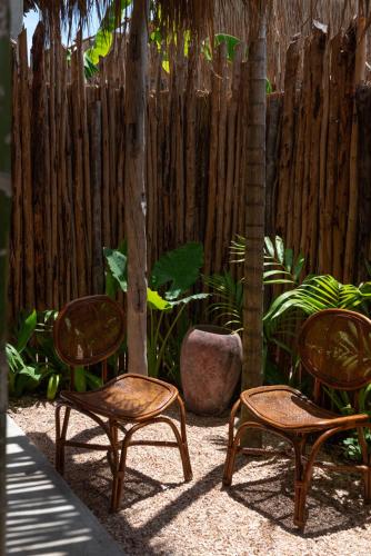 a group of three chairs and a fence at Be Zanzibar Boutique Hotel in Mfumbwi