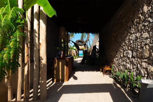a hallway of a building with a stone wall at Be Zanzibar Boutique Hotel in Mfumbwi