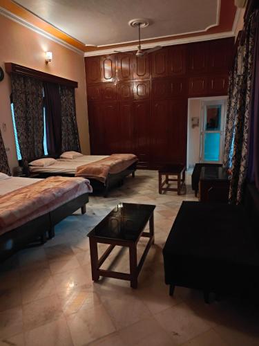 a room with two beds and a table in it at Shantiniketan 2 BHK Homestay in Ayodhya in Ayodhya