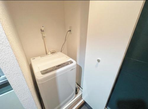 a small bathroom with a washer and dryer at アルカイック103 in Tokyo