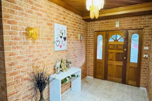 a brick wall with a door and a table with figurines on it at Dhanda Farm Bathurst in Raglan