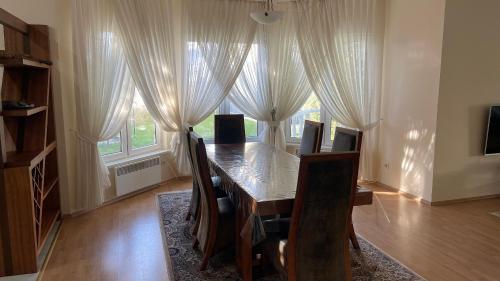 a dining room table with chairs and a large window at Luxury-Family-Cottage in Bosteri