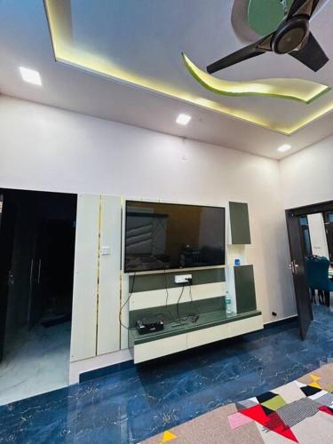 Ajmer villa -3 km from bus stand في أجمير: غرفة معيشة مع تلفزيون بشاشة مسطحة على جدار