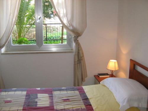 Schlafzimmer mit einem Bett und einem Fenster in der Unterkunft Villa Miriam in Reggio di Calabria
