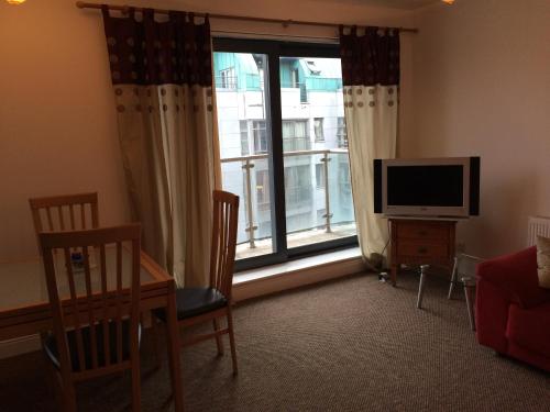 a living room with a television and a large window at 39 Camden Wharf in Cork