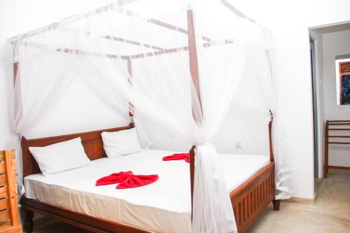 - une chambre avec un lit à baldaquin dans l'établissement Saimon Villa, à Mirissa