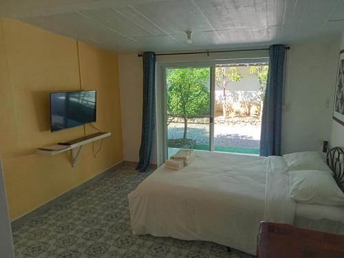 a bedroom with a bed and a tv and a window at Mem Homestay 