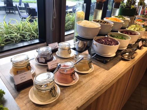 Un buffet con frascos y cuencos de comida sobre una mesa. en Khách Sạn - Resort Oceanami - Long Hải, en Long Hai