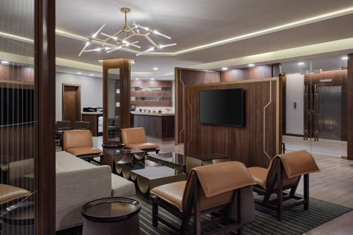 a living room with a couch and a tv at Riyadh Airport Marriott Hotel in Riyadh