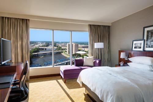 a hotel room with a bed and a large window at JW Marriott Grand Rapids in Grand Rapids
