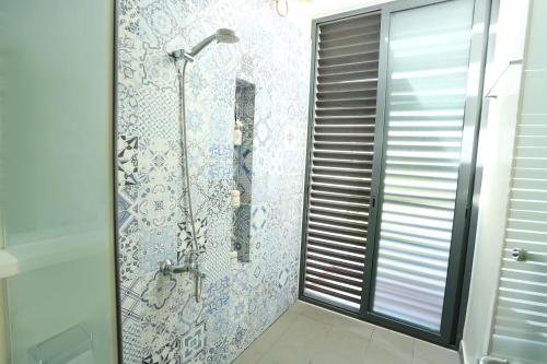 un bagno con doccia con porta in vetro di Khách Sạn - Resort Oceanami - Long Hải a Long Hai