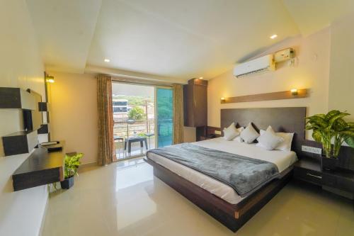 1 dormitorio con cama grande y ventana grande en Berry Fresh Stays Mahabaleshwar With Pool en Mahābaleshwar