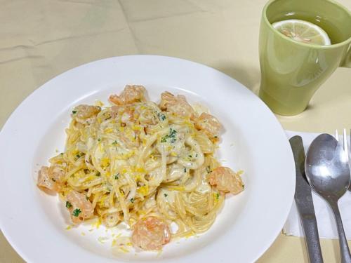 a plate of pasta with shrimp and a cup of coffee at Magnificent International Hotel in Shanghai